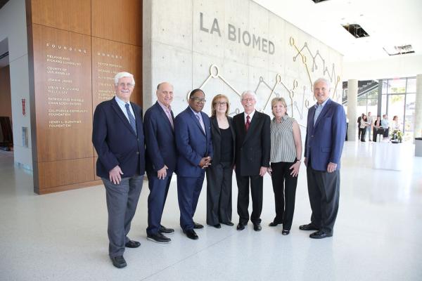 Attendees posing in lobby in front of LA Biomed sign at Medical Research Laboratory Building Dedication